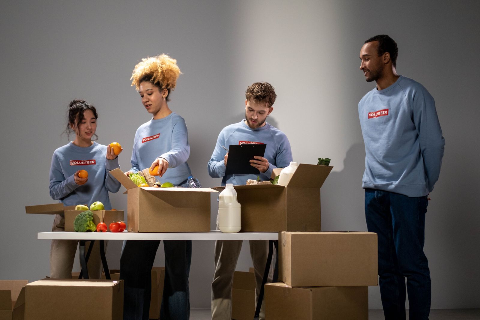 Volunteers packing fresh produce and groceries into donation boxes
